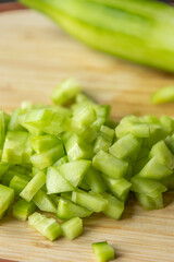  chop fresh cucumber on a wooden cutting board close-up