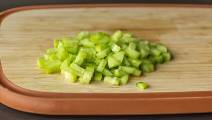  chop fresh cucumber on a wooden cutting board close-up