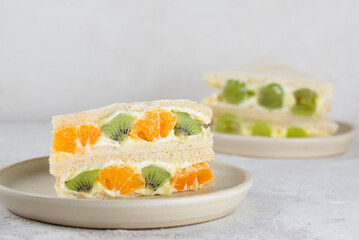 Homemade Korean style bread sandwiches with kiwi, orange, grape and cream cheese on a table. Asian breakfast, street food.