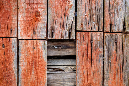 Close-up view of weathered wooden planks displaying rich textures and colors, conveying a rustic charm in a tranquil countryside location.