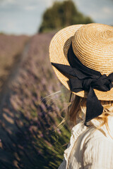 little girl in a straw hat sitting in a lavender field