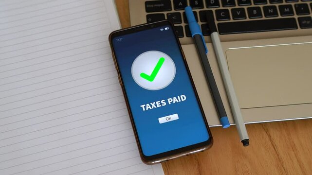 Taxes paid notification on smartphone. Concept of paying taxes online, civil duty and government taxes.