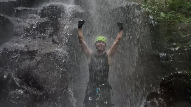 homem mochileiro faz rapel em cachoeira 