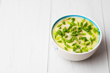 Healthy food, liver pate with butter and green onions in a bowl on light table
