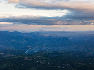 Stunning mountain landscape at dusk with smoke rising from valley below