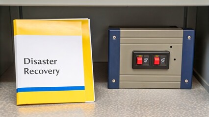 Disaster Recovery Guide on Shelf Next to Control Panel in Office Environment