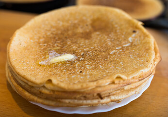Cooking traditional pancakes from wheat flour in the kitchen