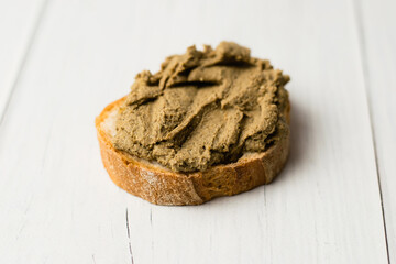 Healthy food, delicious beef liver pate on a baguette with a crispy crust on a light table