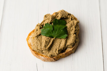 Healthy food, delicious beef liver pate on a baguette with a crispy crust on a light table