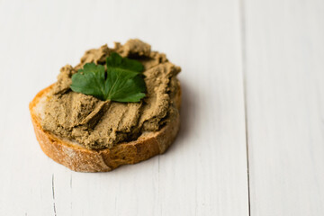 Healthy food, delicious beef liver pate on a baguette with a crispy crust on a light table