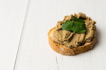 Healthy food, delicious beef liver pate on a baguette with a crispy crust on a light table