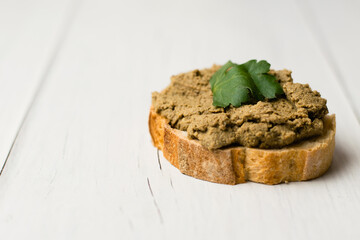 Healthy food, delicious beef liver pate on a baguette with a crispy crust on a light table