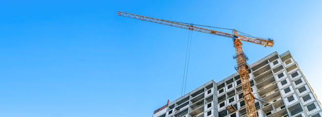 Construction of modern apartments. Construction site with cranes banner background