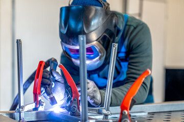 Welder joining metal components using migmag welding technique