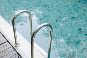 Pool with clear blue water and metal handrails