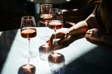 Glasses of rose wine seen in summer sunshine during a wine tasting in a bar or restaurant.