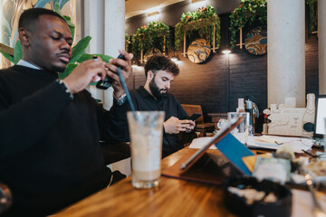 Two business coworkers engaged in work and networking while sitting in a contemporary cafe setting.