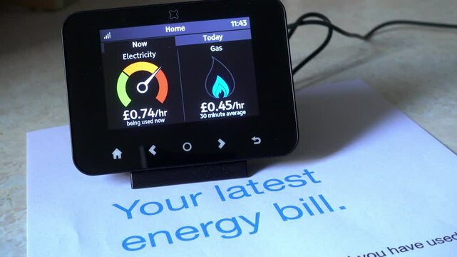 Energy smart meter and consumption account. Electricity and gas meter with the electricity meter needle moving up and down with an account bill.