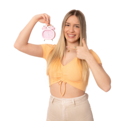 Portrait of cheerful young caucasian woman holding alarm clock isolated over transparent background. PNG transparent