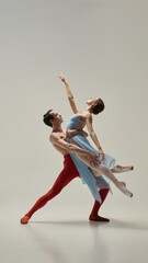 Ballerina lifted in graceful arch, arms reaching toward sky, male partner supporting with strength...