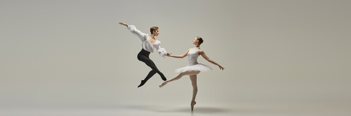 Banner. Ballet duet, young man and woman, dressed elegantly, performing classical dance moves, shows technique and synergy against white background. Concept of beauty and art, music and love.