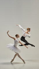 Ballet dancers performing synchronized leap, arms and legs fully extended in fluid, weightless...