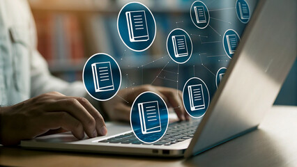 Person working on laptop with document icons overlay, library setting