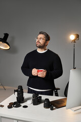 Creative professional contemplating ideas in a stylish workspace while enjoying a warm drink