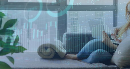 Image of globe of network of connections over caucasian woman using laptop