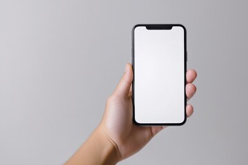 Hand holding smartphone with blank screen.