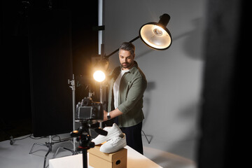 Creative man capturing product shots during a studio photography session for an online store