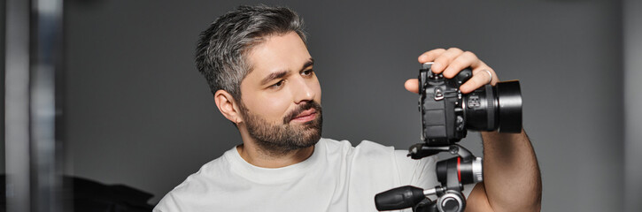 Obraz premium Creative man capturing moments with camera in a modern studio setting