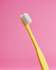toothbrush closeup, yellow background, pink backdrop, product mockup.