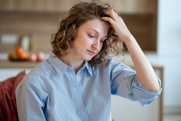 Distressed woman struggling with inner worries from bad news, life troubles, sits alone at home...