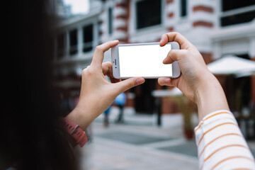 Woman adjusting screen mode while taking selfie in street