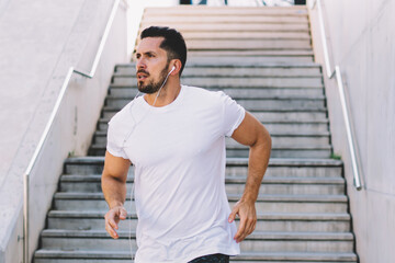 Fototapeta premium Serious man jogging in street of modern city