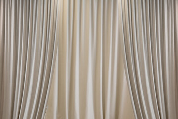 White stage curtain, open at the front and closed at the back