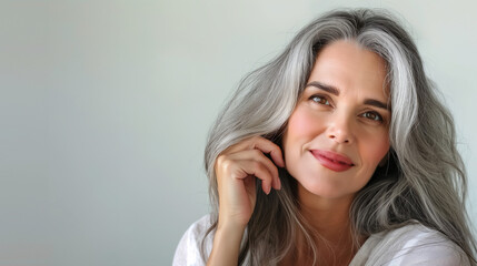 Obraz premium Smiling mature woman with white hair posing in white shirt.