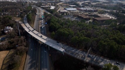 Cars and trucks traveling on Interstate highway through Richmond, VA in afternoon sunshine casting...