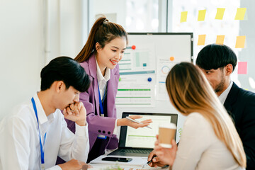 Group of people are sitting around a table with a woman giving a presentation