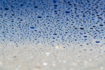 Water droplets on a dark blue ocean color background with customizable space for text or ideas