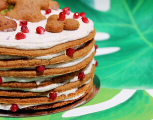 Easter cake – honey cake with white icing, pomegranate, prunes, and grapes, decorated with gingerbread men, multilayered, very delicious