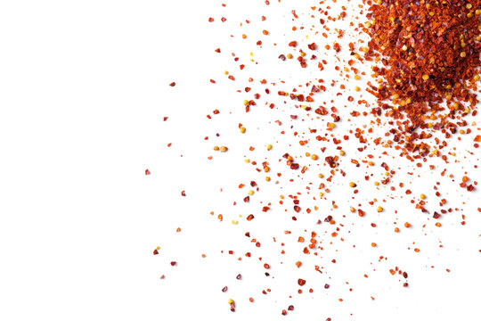 Top view of spicy red chili pepper flakes scattered on transparent or white background