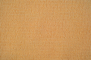 Textile close up of light orange  fabric, fabric texture as a background.
