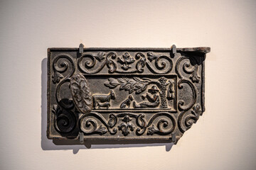Medieval cast-iron stove door with bas-relief of shepherd, dog and sheep