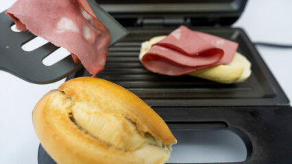 Electric Sandwich Maker Making Sandwiches with Bread and Mortadella
