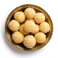 Homemade coconut sweet laddu on golden bowl top view