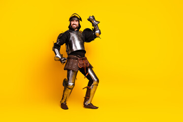 Portrait of an expressive knight in shining armor against a bright yellow backdrop showcasing medieval fashion