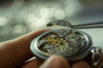 Close up of unrecognizable factory worker assembling intricate mechanical watch, copy space