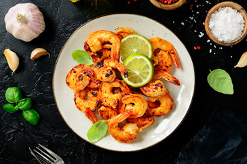 Grilled tiger shrimps with spice and lime. Black background. Top view